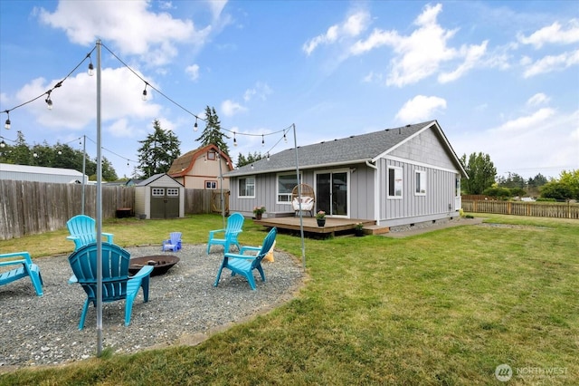 1664 Allyson St, Oak Harbor, WA 98277 - rear view of house featuring an outdoor fire pit, a wooden deck, board and batten siding, a storage unit, and a fenced backyard