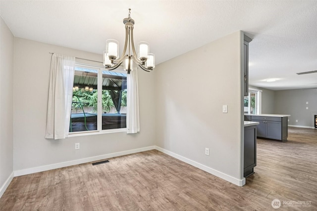 212 SW 2nd Ct, Battle Ground, WA 98604 - unfurnished dining area featuring wood finished floors, a chandelier, and healthy amount of natural light