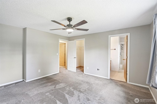 212 SW 2nd Ct, Battle Ground, WA 98604 - unfurnished bedroom with carpet floors, a walk in closet, a textured ceiling, ensuite bath, and a closet