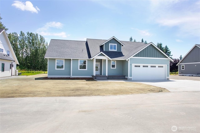 1204 E Georgia Ln, Everson, WA 98247 - view of front of house featuring concrete driveway, an attached garage, board and batten siding, roof with shingles, and covered porch