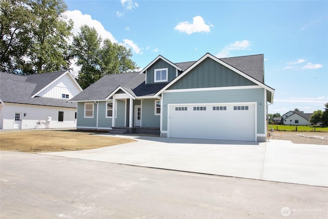 1204 E Georgia Ln, Everson, WA 98247 - view of front of house with board and batten siding, a garage, concrete driveway, and roof with shingles