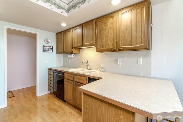 28313 Redondo Way S Unit 304, Des Moines, WA 98198 - kitchen featuring dishwasher, light countertops, backsplash, light wood-type flooring, and a peninsula