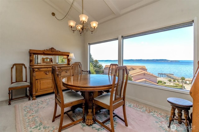 28313 Redondo Way S Unit 304, Des Moines, WA 98198 - dining area featuring a water view, a chandelier, plenty of natural light, and light colored carpet
