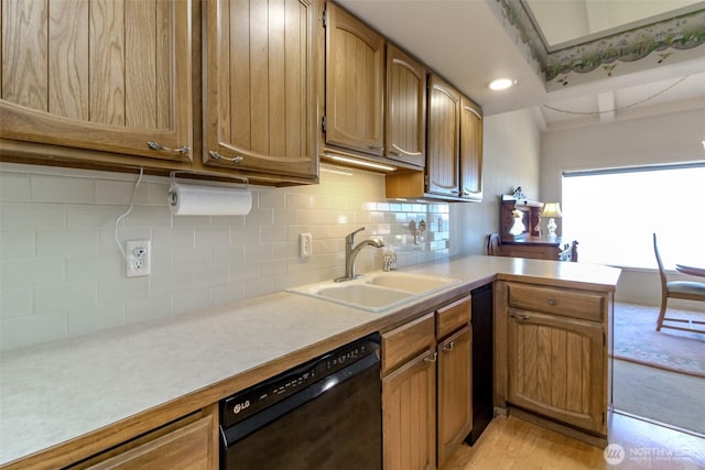 28313 Redondo Way S Unit 304, Des Moines, WA 98198 - kitchen featuring black dishwasher, a peninsula, light countertops, decorative backsplash, and light wood-type flooring