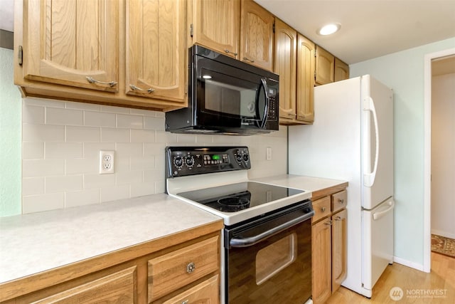 28313 Redondo Way S Unit 304, Des Moines, WA 98198 - kitchen featuring black appliances, light countertops, backsplash, and light wood-style floors