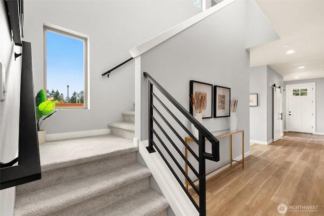 12433 SE 256th Pl Unit 4, Kent, WA 98030 - staircase with a barn door, wood finished floors, recessed lighting, and a towering ceiling