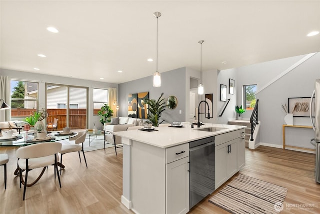 12433 SE 256th Pl Unit 4, Kent, WA 98030 - kitchen featuring stainless steel dishwasher, light wood finished floors, light countertops, a center island with sink, and decorative light fixtures
