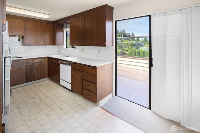 5621 SW Manning St, Seattle, WA 98116 - kitchen with dishwasher, light floors, light countertops, and tasteful backsplash
