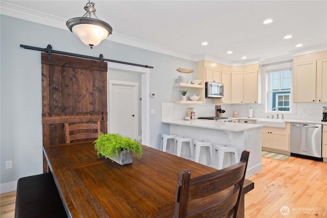 26 Lavender Ln, Pacific Beach, WA 98571 - dining space with crown molding, a barn door, light wood-style flooring, and recessed lighting