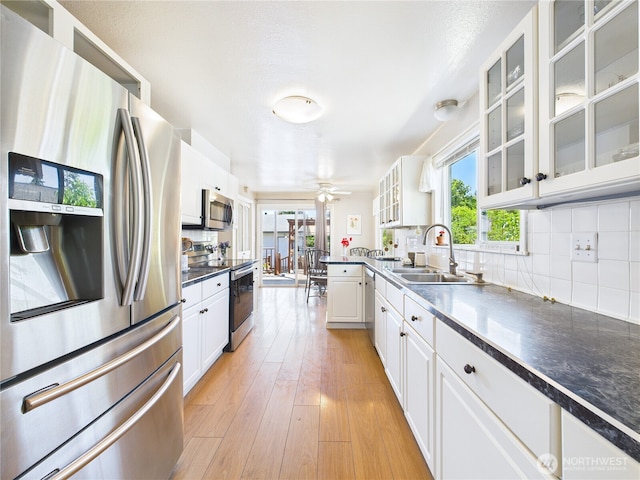 1006 E Harrison St, Tacoma, WA 98404 - kitchen featuring stainless steel appliances, dark countertops, tasteful backsplash, and white cabinets