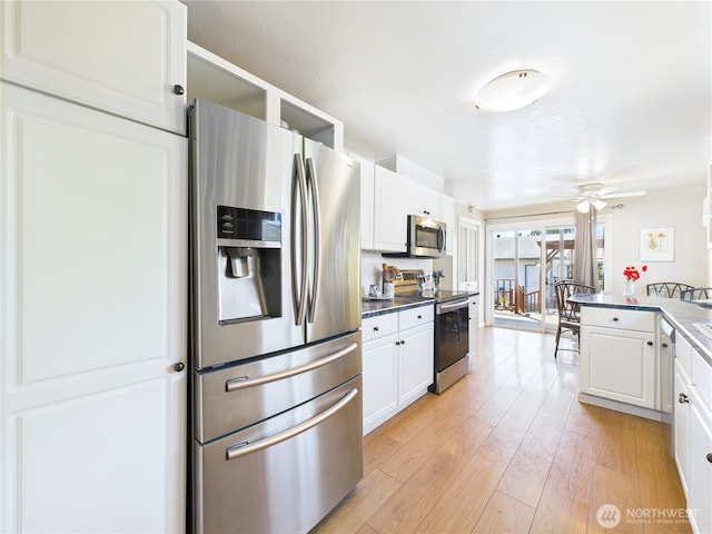 1006 E Harrison St, Tacoma, WA 98404 - kitchen featuring stainless steel appliances, white cabinets, ceiling fan, light wood-style floors, and dark countertops