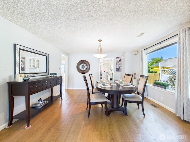 1006 E Harrison St, Tacoma, WA 98404 - dining room with a textured ceiling and light wood-style floors