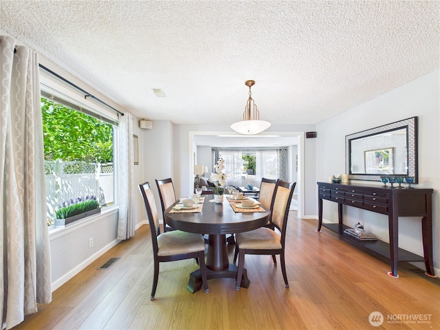 1006 E Harrison St, Tacoma, WA 98404 - dining space featuring a textured ceiling, light wood-style flooring, and healthy amount of natural light