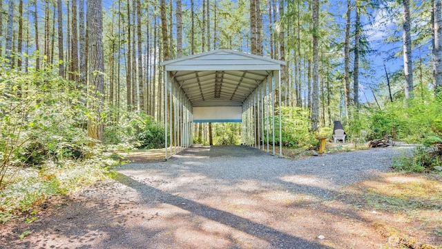 250 E Crest Ln, Grapeview, WA 98546 - view of parking with dirt driveway, a carport, and a view of trees