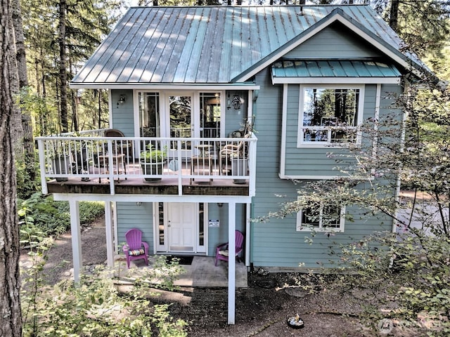 250 E Crest Ln, Grapeview, WA 98546 - view of front of house with a patio, a standing seam roof, a wooden deck, and a metal roof