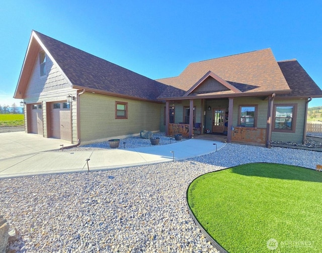 2112 Ringneck Loop, Colville, WA 99114 - view of front facade featuring driveway, roof with shingles, covered porch, brick siding, and a garage