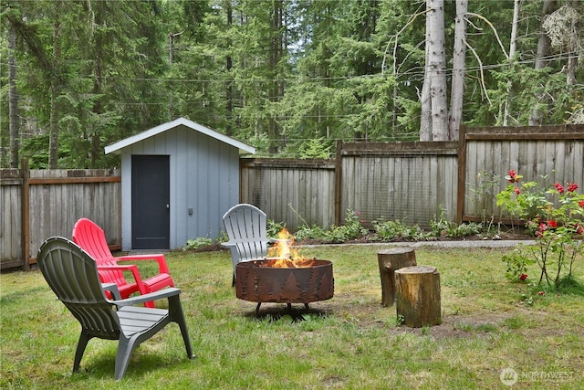 4907 Pinewood Cir, Langley, WA 98260 - fenced backyard featuring an outdoor fire pit and a storage unit