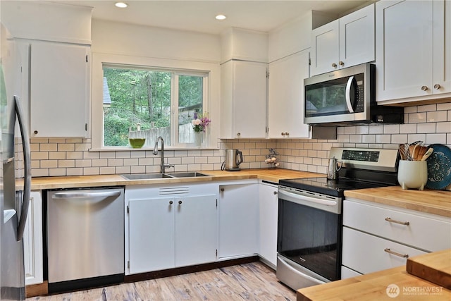 4907 Pinewood Cir, Langley, WA 98260 - kitchen featuring appliances with stainless steel finishes, wooden counters, white cabinetry, tasteful backsplash, and recessed lighting