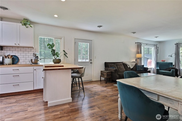4907 Pinewood Cir, Langley, WA 98260 - kitchen featuring wood counters, open floor plan, white cabinets, a breakfast bar, and healthy amount of natural light