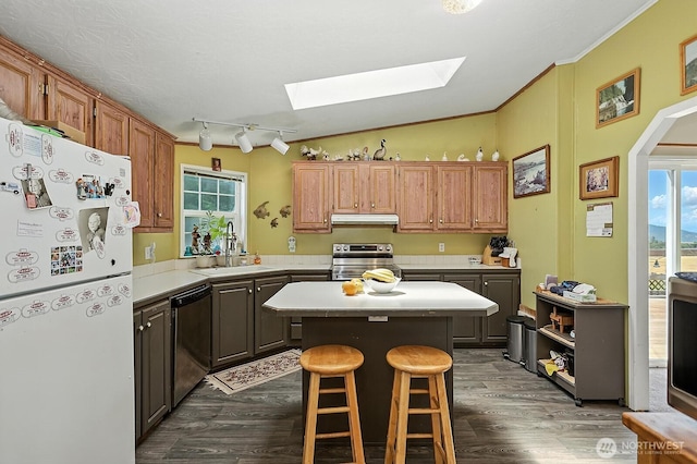 55 Mott Rd, Lyle, WA 98635 - kitchen with appliances with stainless steel finishes, a skylight, light countertops, a kitchen island, and dark wood-type flooring