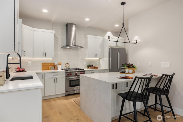 10505 NE 112th St, Kirkland, WA 98033 - kitchen featuring wall chimney exhaust hood, high quality appliances, a breakfast bar, tasteful backsplash, and recessed lighting