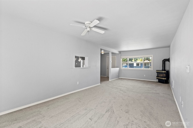 610 128th St S, Tacoma, WA 98444 - unfurnished living room featuring a wood stove, ceiling fan, and carpet