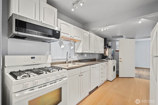 610 128th St S, Tacoma, WA 98444 - kitchen with white appliances, light wood-style floors, white cabinets, washer / dryer, and dark countertops