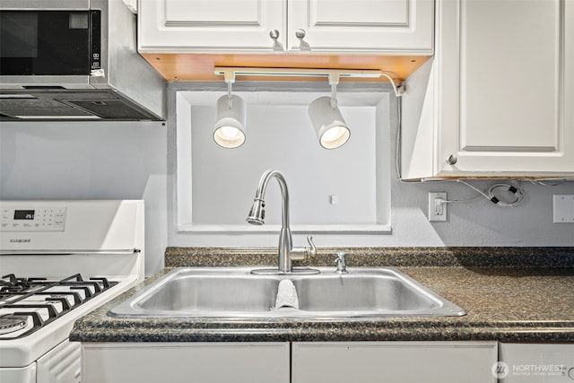 610 128th St S, Tacoma, WA 98444 - kitchen featuring white gas range oven, dark countertops, and white cabinets