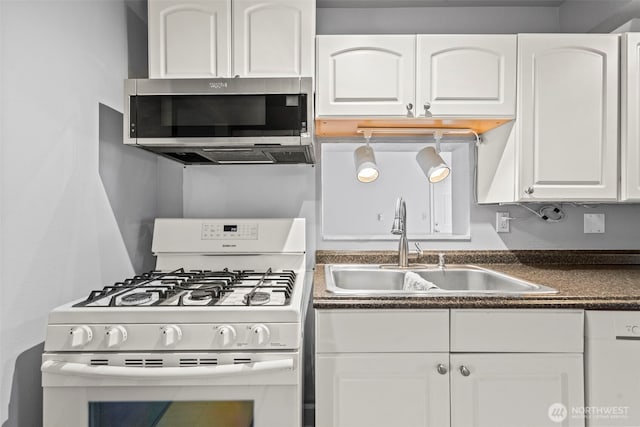 610 128th St S, Tacoma, WA 98444 - kitchen with white appliances, dark countertops, and white cabinetry