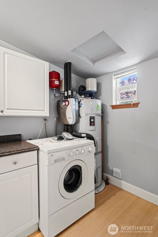 610 128th St S, Tacoma, WA 98444 - laundry area featuring washer / clothes dryer, cabinet space, light wood finished floors, and strapped water heater