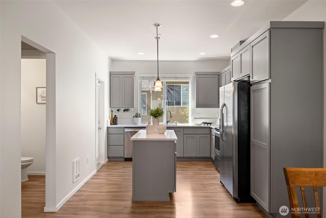 3312 156th St SW Unit E4, Lynnwood, WA 98087 - kitchen with gray cabinets, appliances with stainless steel finishes, a center island, light wood-style flooring, and recessed lighting
