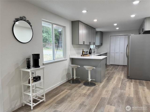 12706 94th Ave E, Puyallup, WA 98373 - kitchen featuring freestanding refrigerator, gray cabinetry, light countertops, light wood finished floors, and recessed lighting