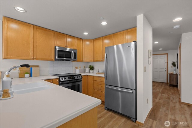 2820 E Madison St Unit 204, Seattle, WA 98112 - kitchen with stainless steel appliances, light wood-type flooring, light countertops, backsplash, and recessed lighting
