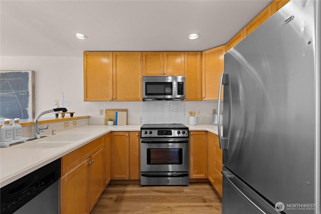 2820 E Madison St Unit 204, Seattle, WA 98112 - kitchen with stainless steel appliances, light countertops, light wood finished floors, recessed lighting, and tasteful backsplash