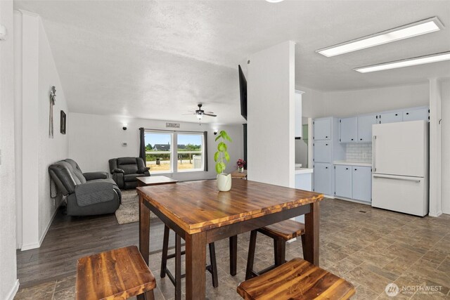 8222 Bordeaux Rd SW, Olympia, WA 98512 - dining space featuring ceiling fan, stone finish flooring, and lofted ceiling