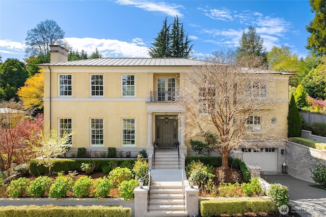 2001 Broadmoor Dr E, Seattle, WA 98112 - view of front of property featuring a standing seam roof, stucco siding, an attached garage, a chimney, and driveway