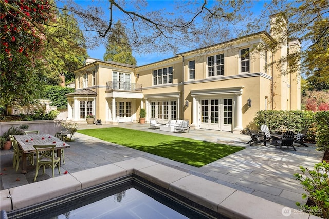 2001 Broadmoor Dr E, Seattle, WA 98112 - back of property with french doors, a balcony, an outdoor living space with a fire pit, a patio area, and stucco siding