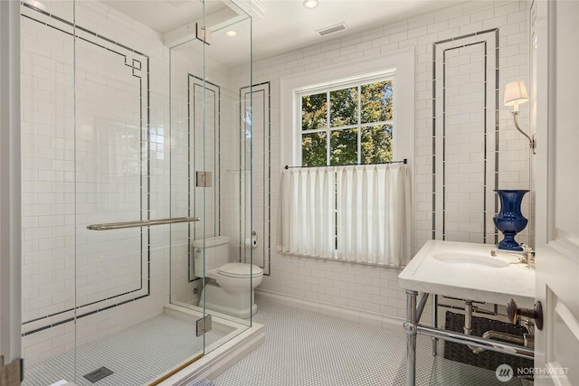 2001 Broadmoor Dr E, Seattle, WA 98112 - bathroom featuring a stall shower, tile walls, tile patterned flooring, and recessed lighting