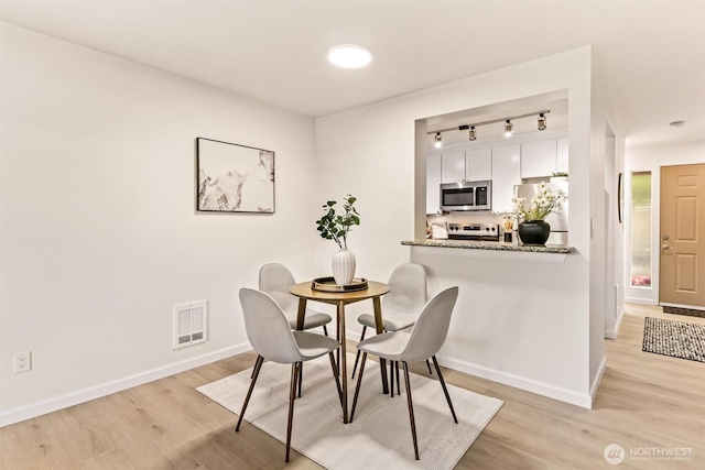502 141st Ave SE Unit 45, Bellevue, WA 98007 - dining space featuring track lighting and light wood-type flooring