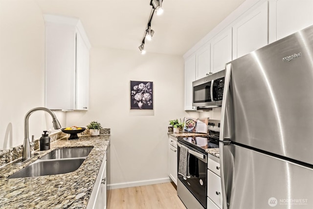 502 141st Ave SE Unit 45, Bellevue, WA 98007 - kitchen with stainless steel appliances, light wood-style flooring, white cabinetry, light stone counters, and rail lighting