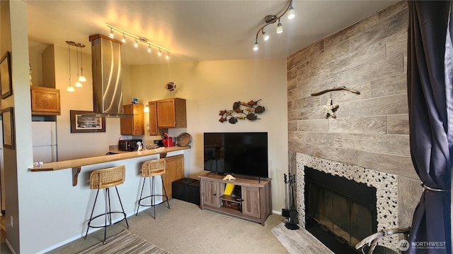 835 Ocean Shores Blvd NW Unit 305, Ocean Shores, WA 98569 - kitchen with freestanding refrigerator, brown cabinets, wall chimney range hood, light carpet, and rail lighting