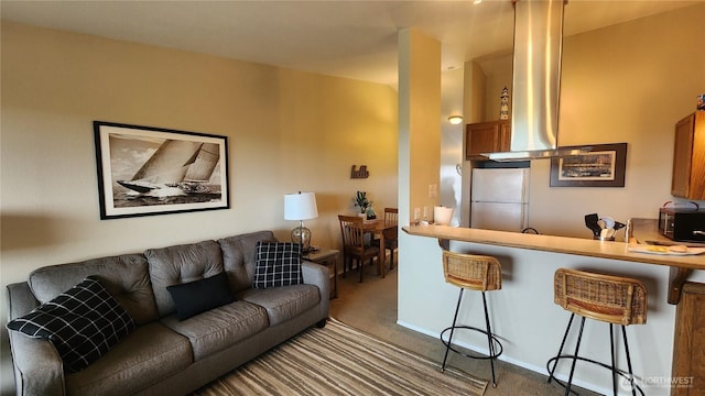835 Ocean Shores Blvd NW Unit 305, Ocean Shores, WA 98569 - kitchen featuring freestanding refrigerator, carpet, a breakfast bar, and wall chimney exhaust hood