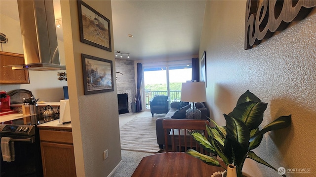 835 Ocean Shores Blvd NW Unit 305, Ocean Shores, WA 98569 - carpeted living room featuring a fireplace, rail lighting, and a textured wall