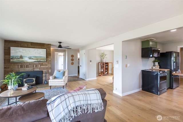 110 Victoria View St, Sequim, WA 98382 - living room with light wood-type flooring, ceiling fan, and a wood stove