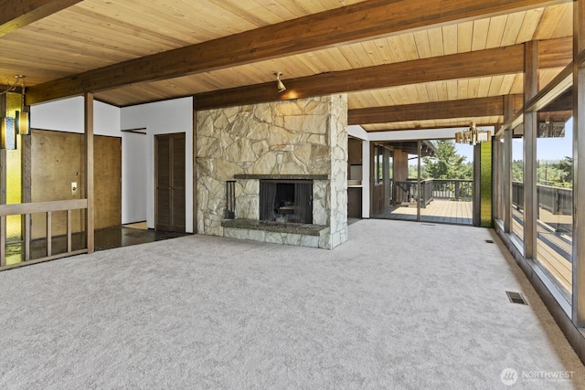 21030 6th Ave S, Des Moines, WA 98198 - unfurnished living room with carpet floors, a wooden ceiling with exposed beams, an outdoor stone fireplace, and a chandelier