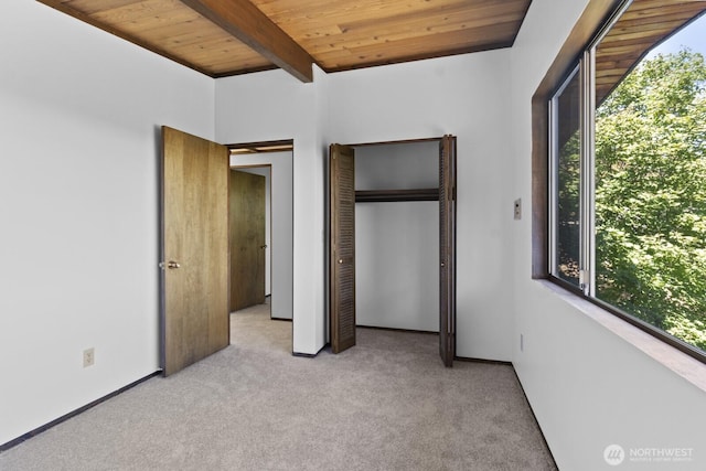 21030 6th Ave S, Des Moines, WA 98198 - unfurnished bedroom featuring a wooden ceiling with exposed beams, multiple windows, light carpet, and a closet