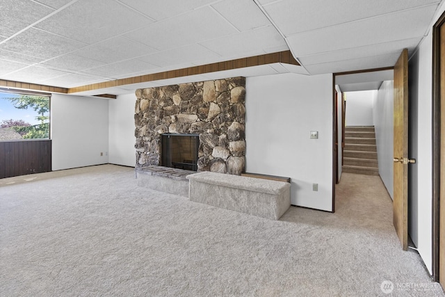 21030 6th Ave S, Des Moines, WA 98198 - unfurnished living room with light colored carpet, stairway, a fireplace, and a drop ceiling