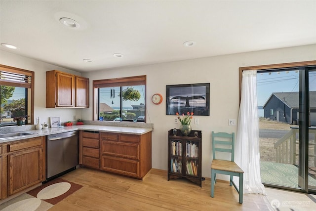 27523 SW Sandy Shores Dr, Vashon, WA 98070 - kitchen featuring stainless steel dishwasher, plenty of natural light, brown cabinetry, light wood-style floors, and recessed lighting