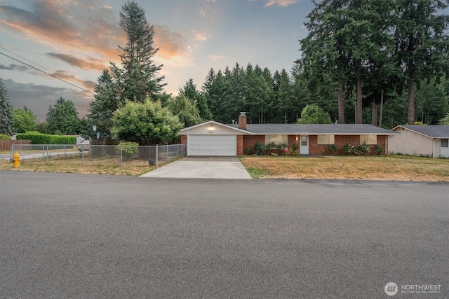 2598 25th Loop SE, Lacey, WA 98503 - ranch-style house with a garage, driveway, a chimney, brick siding, and view of scattered trees
