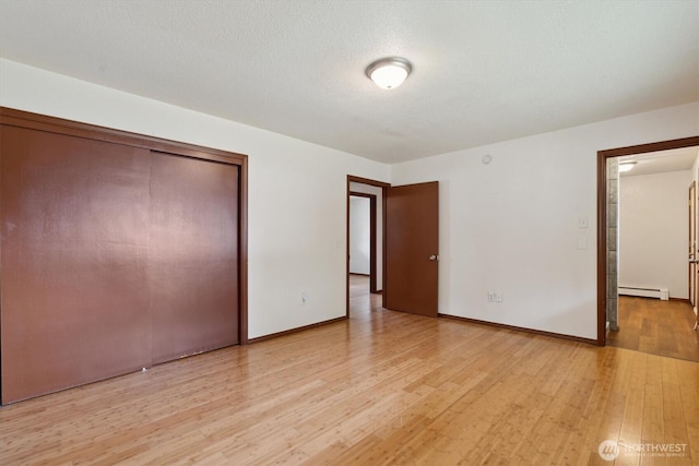 2598 25th Loop SE, Lacey, WA 98503 - unfurnished bedroom featuring light wood-style flooring, a baseboard radiator, and a closet